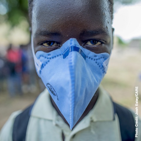 A young boy wears a mask at a Hygiene Promotion at Nharuchonga Primary School